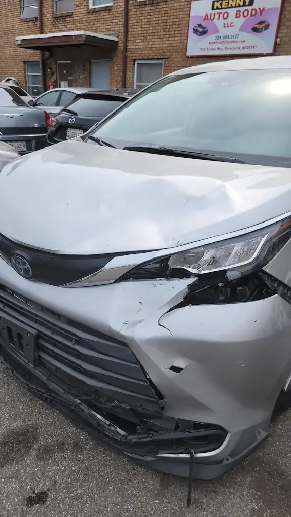 Damaged minivan arriving at Kenny Auto Body for an insurance claim